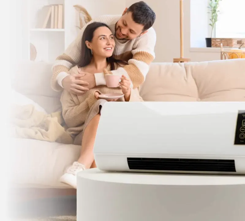 A couple relaxing on the sofa next to a Heatoor heater